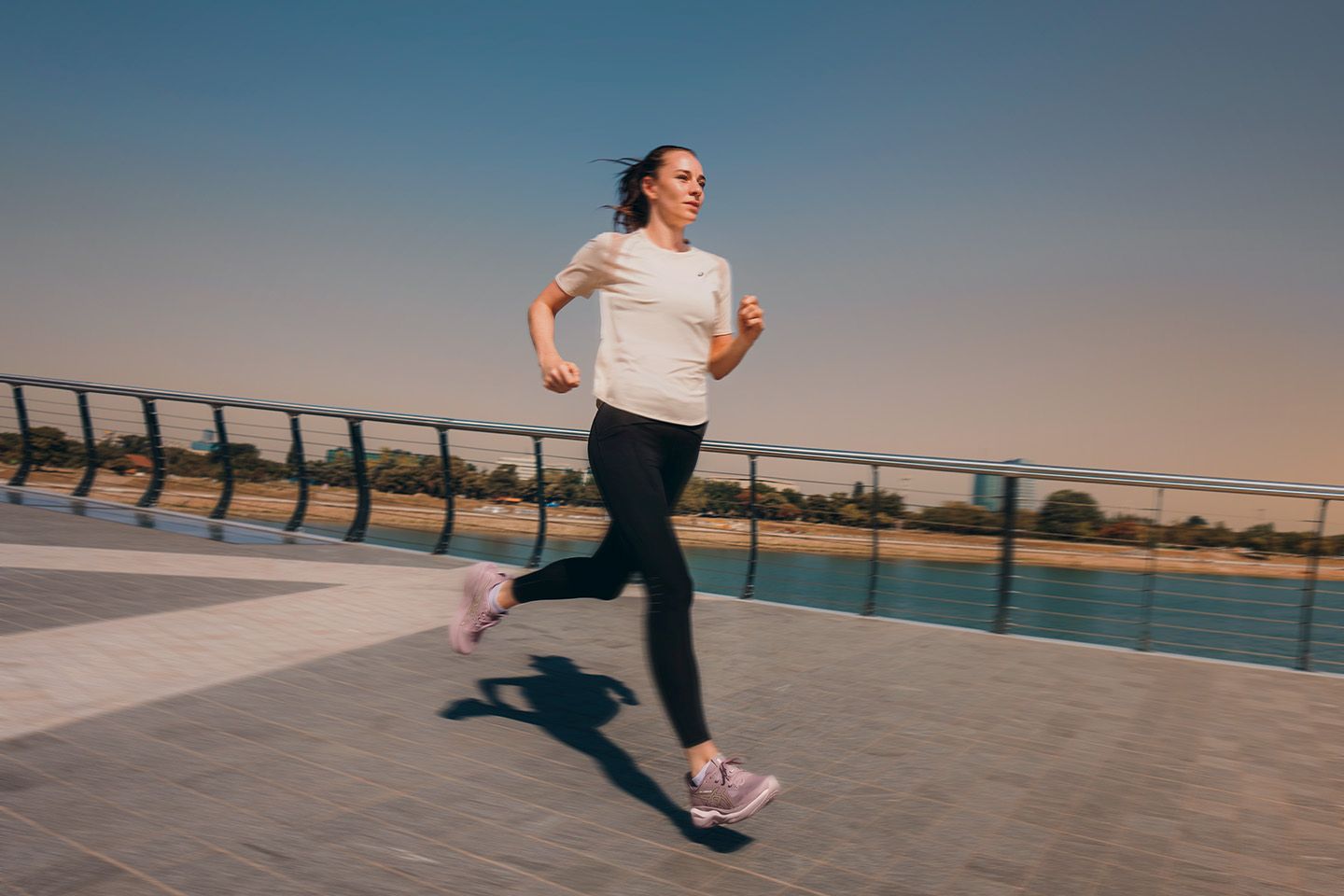 Biegaczka w butach ASICS GEL-NIMBUS 29 na bulwarze nad wodą