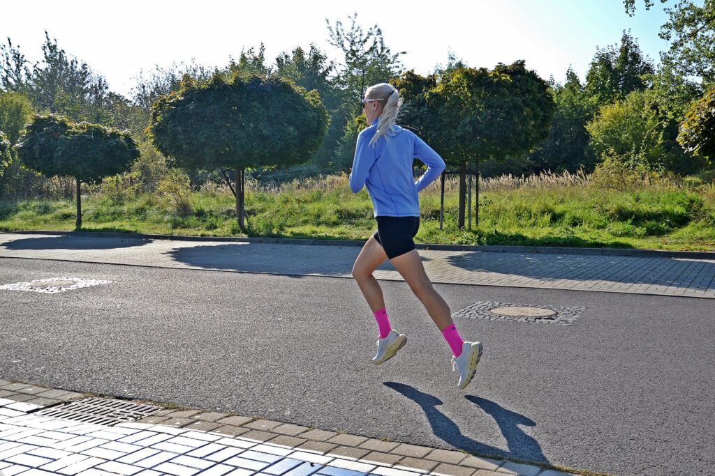 Biegaczka biegnie po asfalcie w butach ON Cloudrunner 3 Max